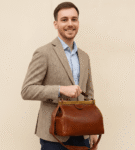 Vintage doctor-style leather bag in rich brown full-grain calfskin with brass frame closure and top handle, perfect for timeless everyday or travel elegance