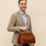 Vintage doctor-style leather bag in rich brown full-grain calfskin with brass frame closure and top handle, perfect for timeless everyday or travel elegance