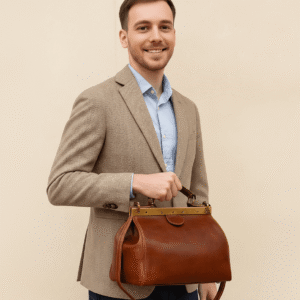 Vintage doctor-style leather bag in rich brown full-grain calfskin with brass frame closure and top handle, perfect for timeless everyday or travel elegance