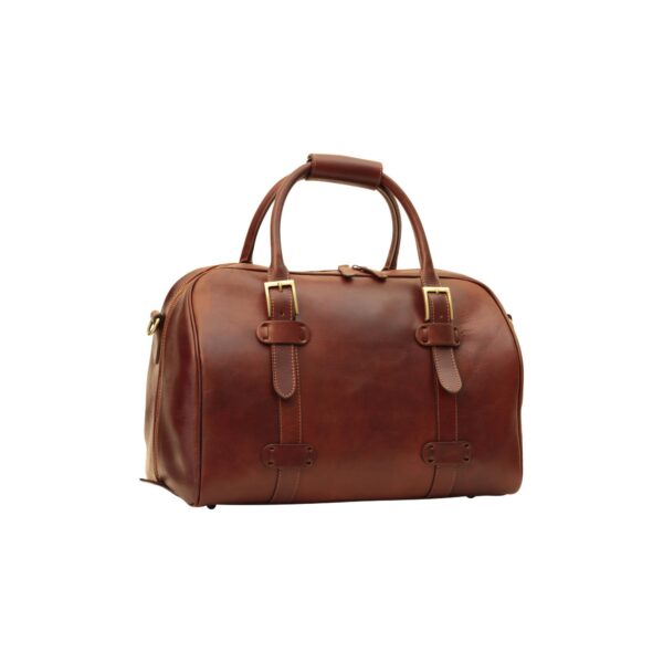A chestnut brown leather weekender bag shown at a three-quarter angle on a white background, featuring gold-tone buckles on the front, two top handles with a leather wrap-around grip, and visible stitching along the decorative straps.