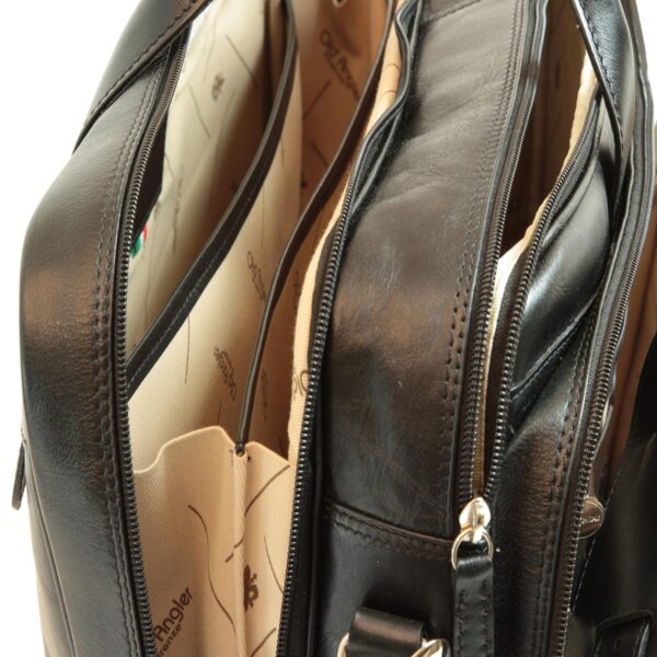 Internal view of a black leather bag featuring multiple zippered compartments and a light-colored lining branded with the Old Angler logo.