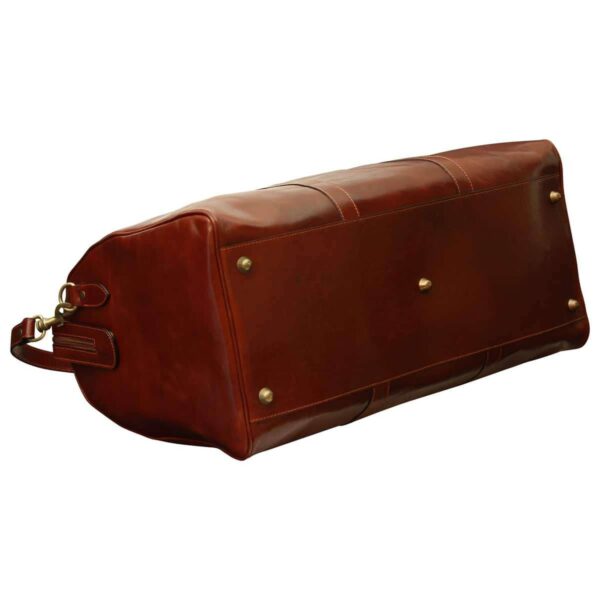 Bottom view of a brown leather duffel bag showing metal protective feet and reinforced base.