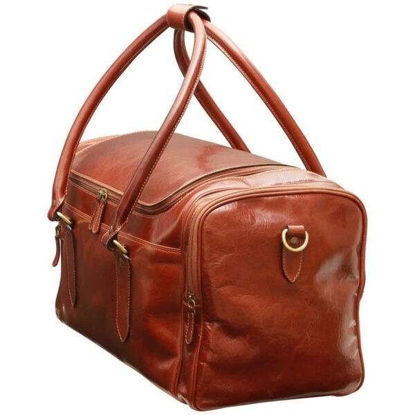 leather duffel bag in a rich cognac-brown color, highlighting the natural grain and sheen of the leather. It features the same double-zippered design, side compartment, and sturdy handles with gold-toned metal attachments.