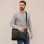Luxury leather messenger bag with adjustable strap, laptop compartment, and organized pockets