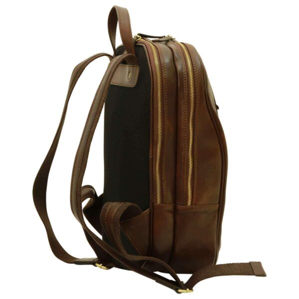 A side-profile view of a dark brown leather backpack against a white background. The bag features two main zippered compartments with gold-tone hardware, a top carry handle, adjustable shoulder straps, and a breathable black mesh padded back panel.