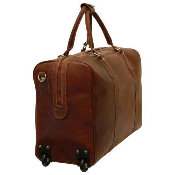 A three-quarter rear view of a cognac leather rolling duffel bag, showing two sturdy wheels at the base, a side zippered pocket, and dual top handles with a leather wrap.