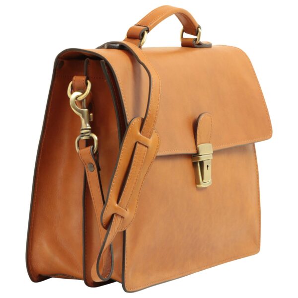 Three-quarter studio shot of a tan leather briefcase with a top handle, adjustable shoulder strap featuring a padded section and brass hardware, and a metallic push-lock closure on the front flap.