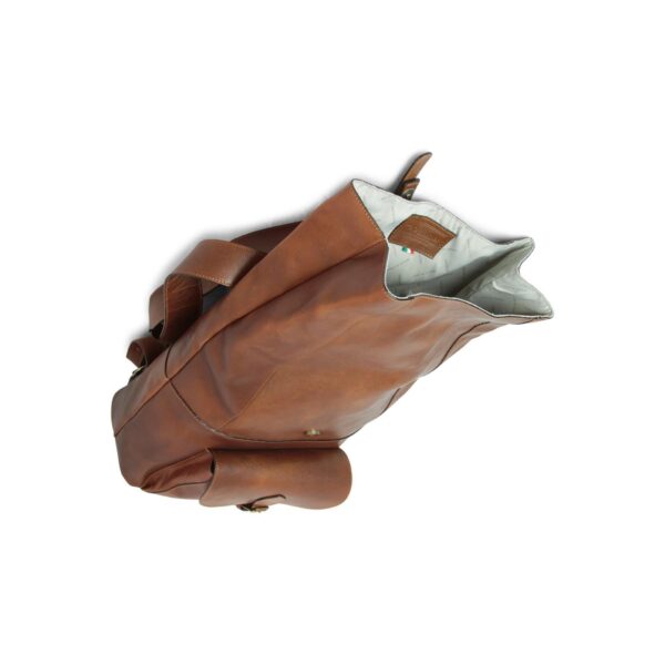 Top-down view of an open tan leather backpack with a slouchy, bucket-style design. The image highlights the cream-colored interior lining with "MADE IN ITALY" branding and a brown leather logo patch, while also showing a small exterior pocket on the side and a wide leather shoulder strap.