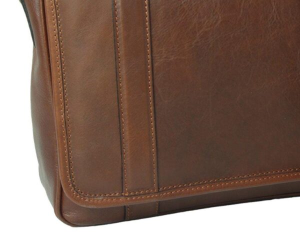 A close-up of a brown leather bag showing the detailed texture of the material and the precision of the stitching. The leather has a slightly weathered, natural grain, and the vertical straps are reinforced with neat, double-stitched borders.