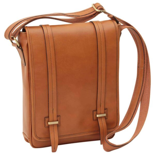 A front-angled view of a tan leather messenger bag featuring a slim vertical silhouette, dual decorative vertical straps on the front flap with brass hardware, and a matching adjustable canvas shoulder strap.