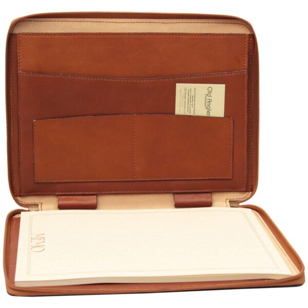 An open brown leather zippered portfolio featuring a writing pad on one side and internal storage pockets with an Old Angler business card on the other.