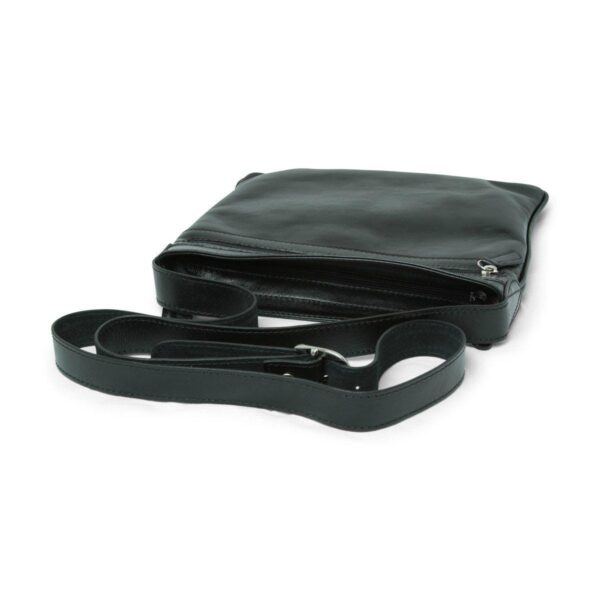 A three-quarter view of a flat black leather crossbody bag lying on a white surface, featuring an open top zipper and a matching adjustable leather shoulder strap with a silver buckle.