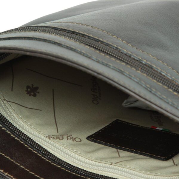 Close-up view of the interior of a black leather bag, showing a branded beige fabric lining with the "Old Angler Firenze" logo, an internal zippered pocket, and a dark leather patch.