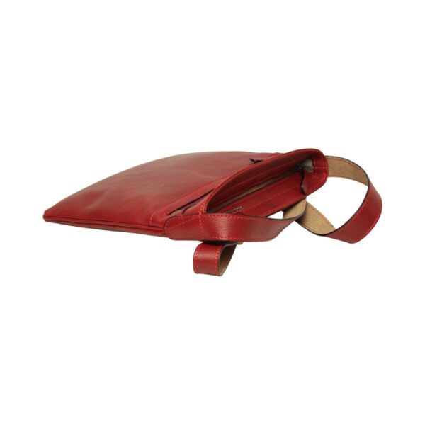 A high-angle view of a red leather crossbody bag lying flat, with its main zippered compartment open to reveal a light-colored interior lining.