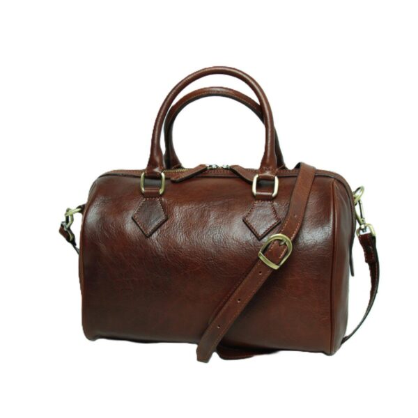 A dark brown, textured leather Boston bag featuring rolled top handles and a detachable, adjustable shoulder strap with a brass buckle. The bag has a zippered top and diamond-shaped leather patches at the handle bases, presented on a white background.