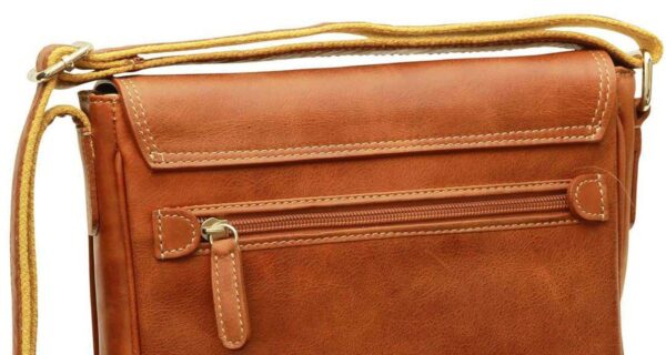 A close-up of a tan leather messenger bag featuring a horizontal zippered back pocket, a top flap with visible stitching, and a light-colored canvas shoulder strap.