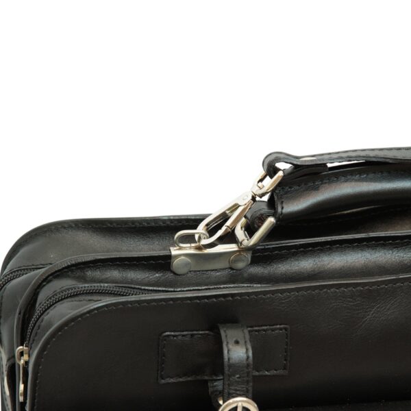 Close-up detail of a black leather bag featuring a silver metal lobster clasp, a sturdy top handle, and zippered compartments