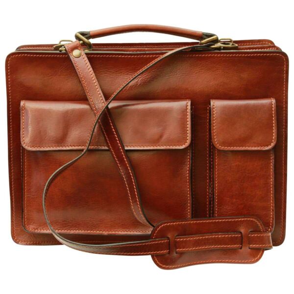 A front view of a cognac-colored leather briefcase featuring two external front pockets with flap closures, a sturdy top handle, and a matching leather shoulder strap with a padded section for comfort.