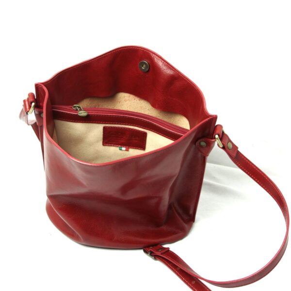 Red leather shoulder bag with adjustable strap, spacious interior, and zip pocket detail on white background