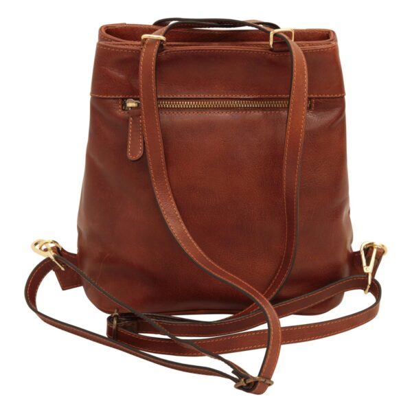 A rear view of a cognac-brown leather shoulder bag with its long adjustable straps resting in front, featuring a horizontal zippered pocket and gold-toned hardware against a white background.
