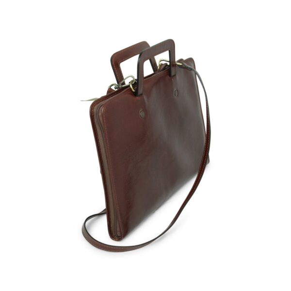 Three-quarter view of a slim brown leather document case or laptop bag, featuring a top zipper, two integrated rectangular leather handles, and a thin detachable leather shoulder strap.