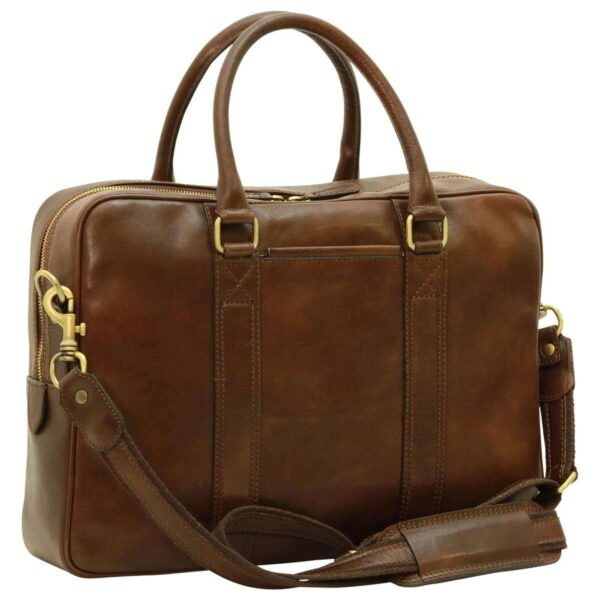 Three-quarter view of a smooth brown leather laptop bag with rounded top handles, gold-tone zippers, and a detachable leather shoulder strap.