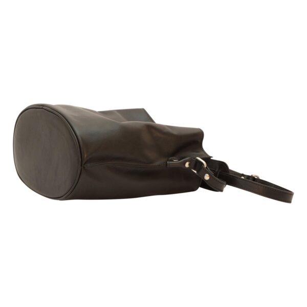 A studio shot from a low angle showing a black leather bucket bag lying on its side, highlighting its smooth texture and structured oval base against a white background.
