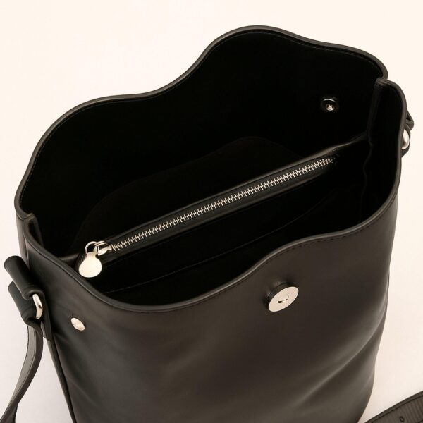 An interior view of an open black leather bucket bag, showcasing a dark lining, a central zippered compartment with silver-toned hardware, and a magnetic snap fastener, set against a white background.