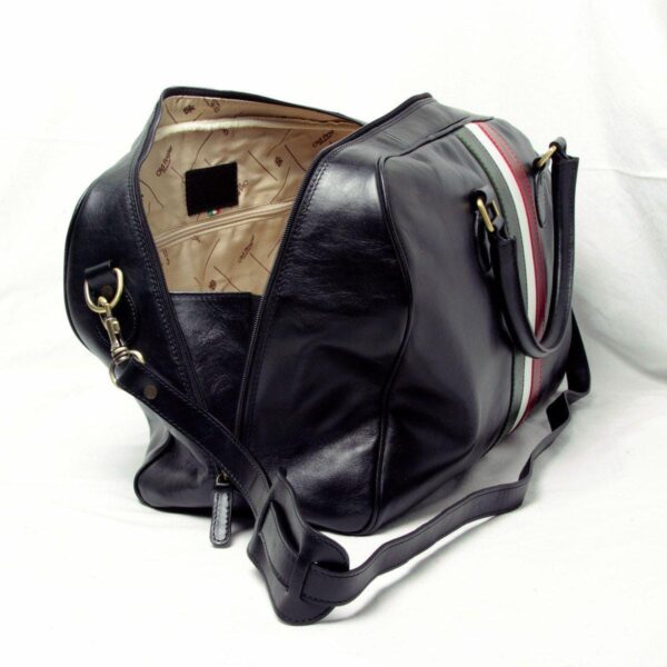 An open black leather duffel bag shown from a high angle, revealing a beige patterned interior lining with a zippered pocket and a branded patch, against a white background.