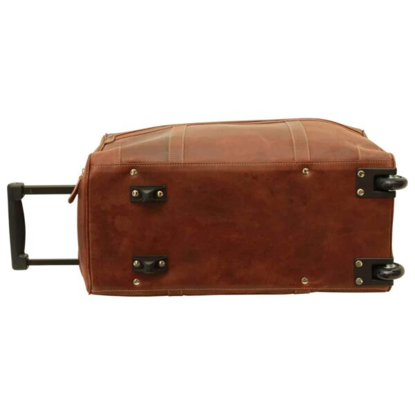 A view of the bottom of a brown leather rolling duffel bag, showing two wheels, protective studs, and the telescopic handle extended to the side.