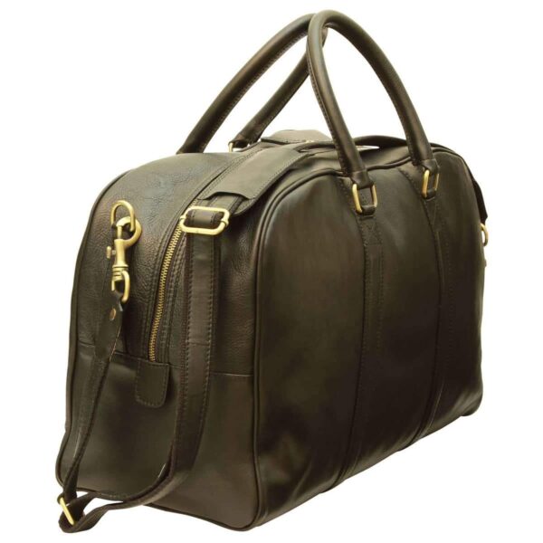 A high-angle, side view of a dark brown leather duffel bag featuring a pebbled texture and antique brass-style hardware. The bag includes dual rounded top handles and an adjustable shoulder strap attached via lobster clasps. It is shown against a plain white background.