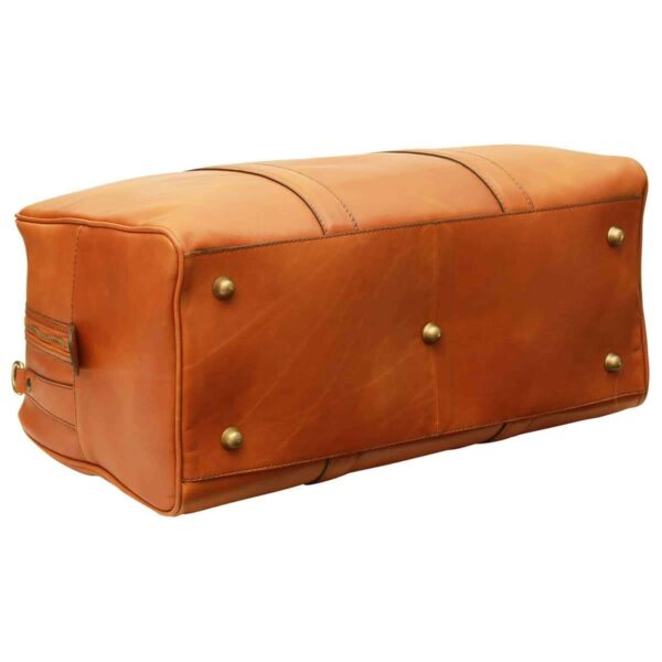 A view of the bottom and side of a large tan leather duffel or weekender bag. The bottom features five brass-colored protective metal feet (studs) to prevent wear. Two leather reinforcement straps wrap around the body of the bag, and a side zipper with a leather pull tab is visible, all set against a plain white background.