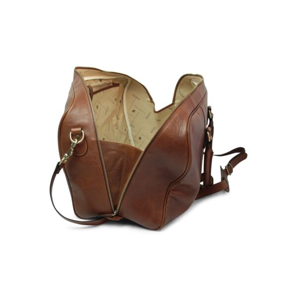 Brown leather duffle bag shown open with a patterned cream interior lining, gold-tone zipper and hardware, and an adjustable shoulder strap, on a white background