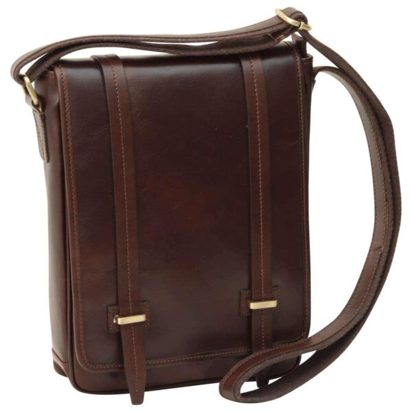 A front-angled view of a dark brown leather messenger bag featuring a vertical design, two decorative leather straps with brass buckles on the front flap, and a matching adjustable leather shoulder strap.