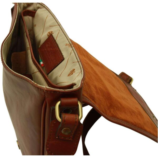 Close-up interior view of an open brown leather messenger bag featuring a patterned fabric lining, a leather brand tag, and a suede-lined flap