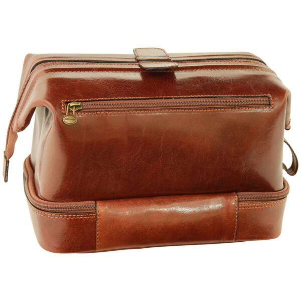 An open view of a brown leather toiletry bag, specifically highlighting the zippered bottom compartment. The interior is lined with a cream-colored fabric featuring the "Old Angler Firenze" logo and fleur-de-lis motifs, matching the structured "doctor bag" design of the upper section.