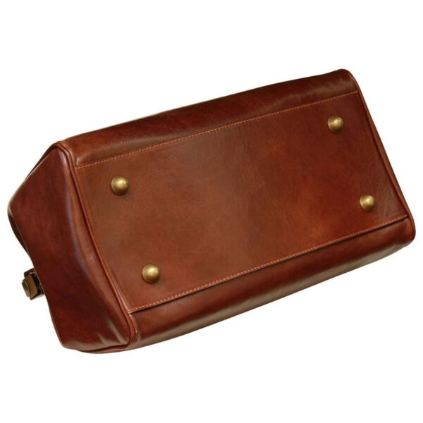 An underside view of a vintage-style brown leather doctor's bag, showing the rectangular base with reinforced stitching and four protective brass-toned metal feet.