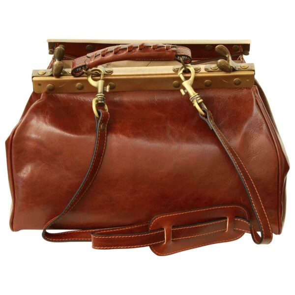 A front-view shot of a vintage-style brown leather doctor's bag, shown with the brass-toned metal frame open. The image features a detachable leather shoulder strap with a sliding comfort pad, secured to the frame by two brass swivel lobster clasps.