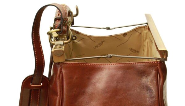 A high-angle, close-up shot showing the open compartment of a vintage-style brown leather doctor's bag. The image highlights the "Old Angler" branded fabric lining, the collapsible metal stay-open frame, and the leather shoulder strap with a comfort pad attached to the side.