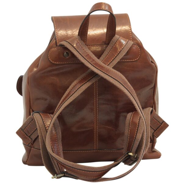 A back-view shot of a vintage-style brown leather backpack, featuring adjustable canvas shoulder straps that are crossed over the back panel. The bag includes a small leather top handle and is made from polished, high-quality leather with visible vertical stitching.