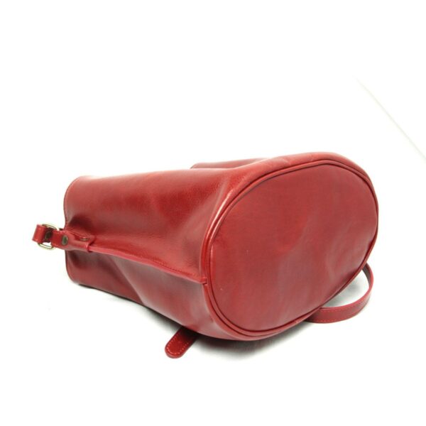 Bottom view of red leather shoulder bag showing oval base and white background