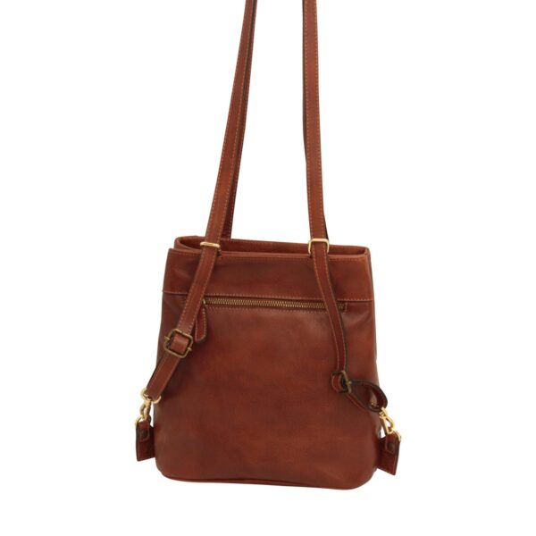 The back view of a cognac-brown leather shoulder bag, featuring a horizontal zippered exterior pocket, gold-toned metal hardware, and long adjustable leather straps against a white background.