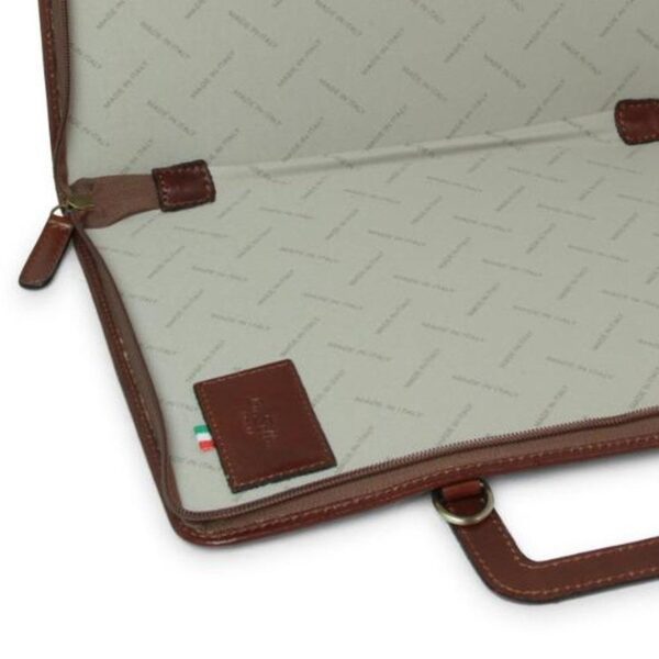 Close-up interior view of an open brown leather document case, showing a light grey fabric lining with a repeating "Made in Italy" pattern and a small leather logo patch.